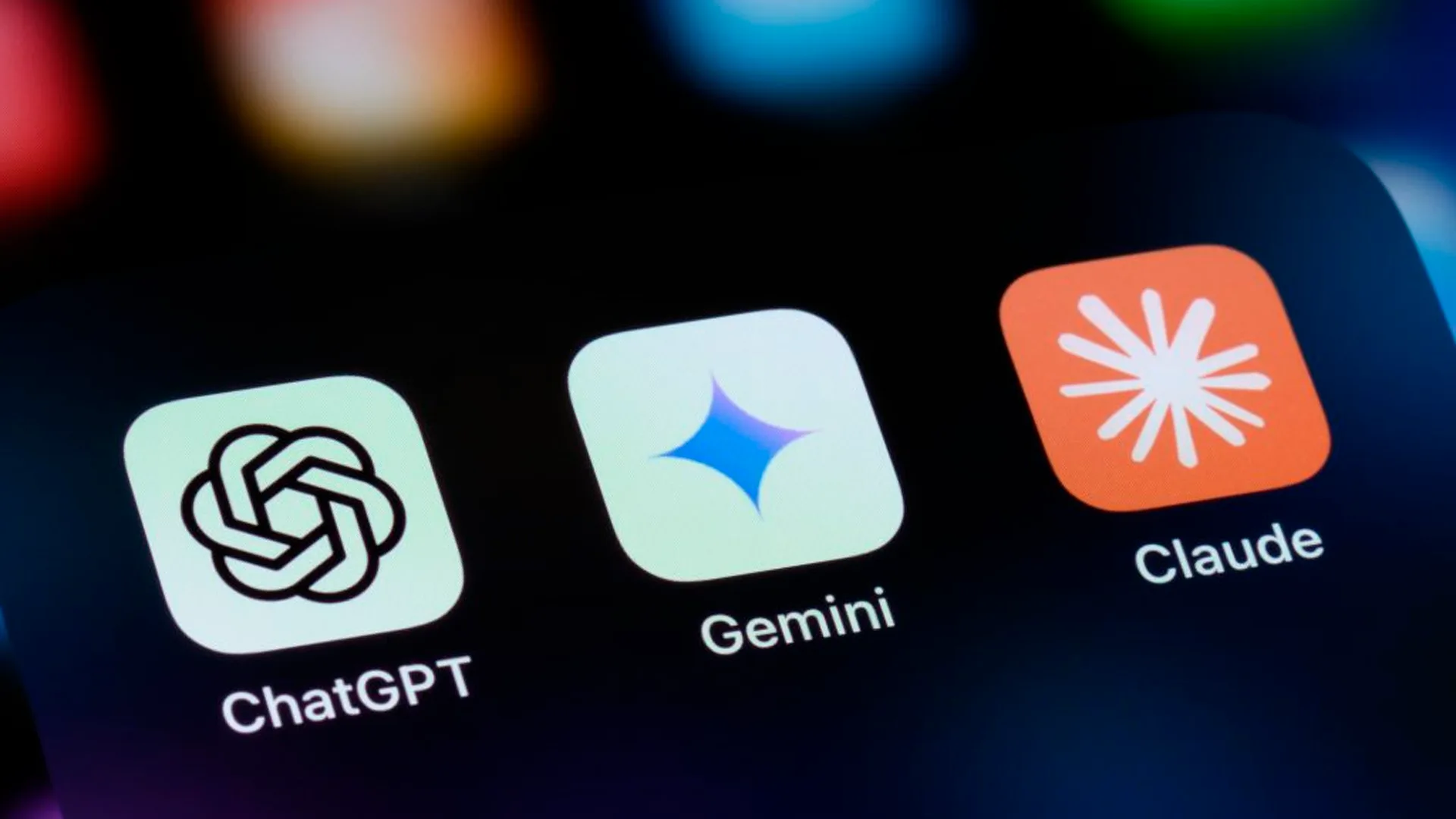 Ícones das aplicações de IA ChatGPT, Gemini e Claude alinhados num ecrã de smartphone.
