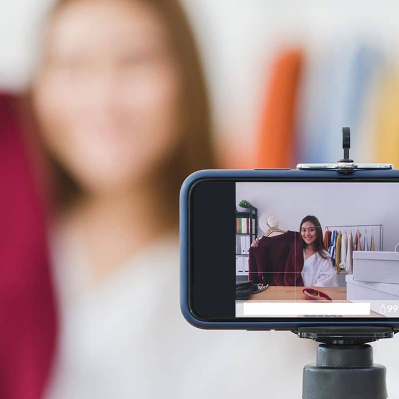 woman doing a livestreaming demonstrating clothing