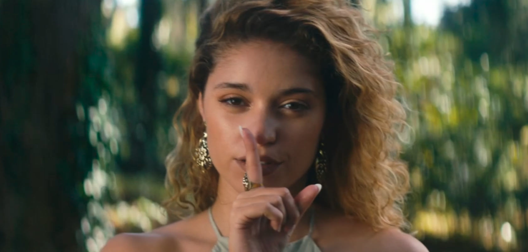 Mulher com indicador a indicar silencio