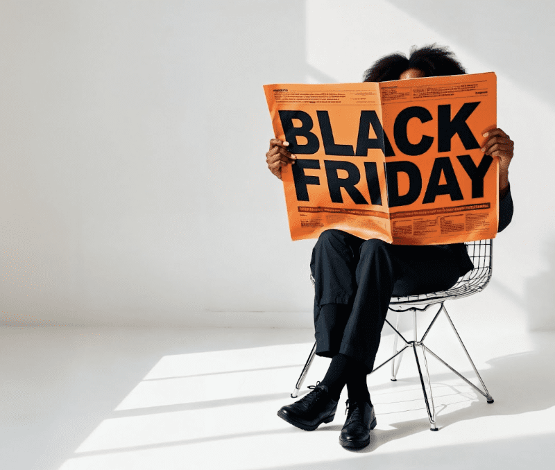 homem sentado ler jornal black friday