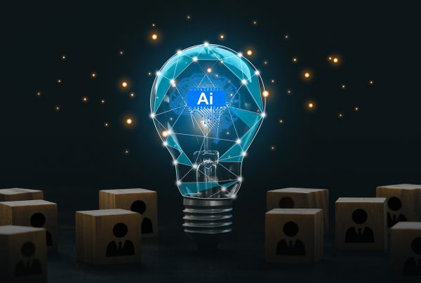 Lâmpada brilhante com elementos digitais representando inteligência artificial no centro, cercada por blocos de madeira com ícones de pessoas, simbolizando tecnologia e inovação em ambientes corporativos.